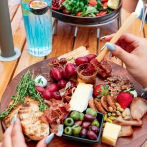 Vibrant charcuterie board with an assortment of meats, cheeses, fruits, and olives, perfect for gourmet dining.